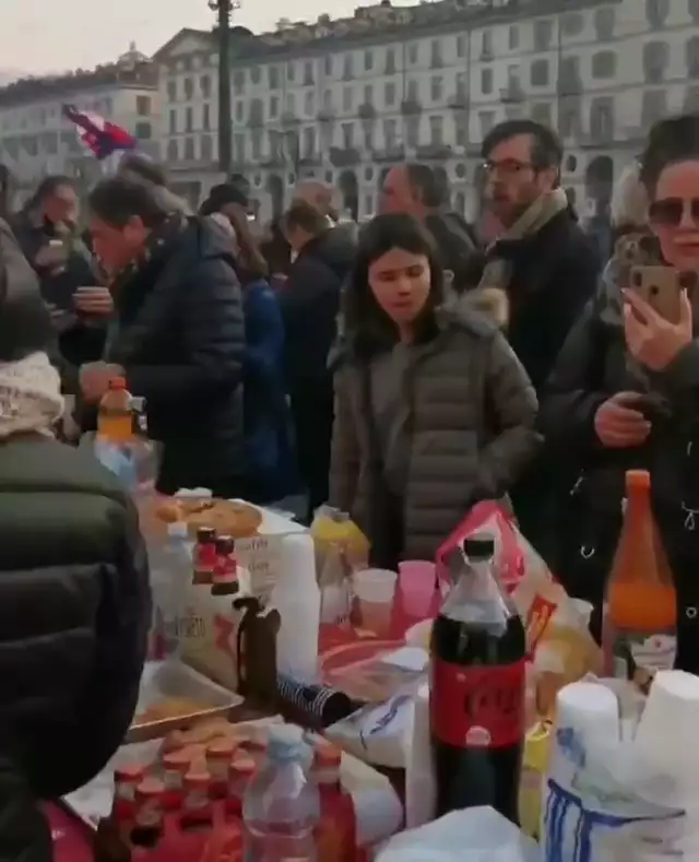 In Turin essen viele Menschen draussen an einem reich gedeckten Tisch, unabhängig von ihrem Impfstatus